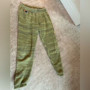 Green Aviator Nation camouflage sweatpants with a yellow lightning bolt